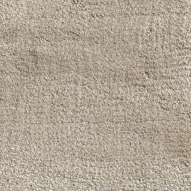 Warm oatmeal carpet textile with dense nubby loops and softly mottled beige shading