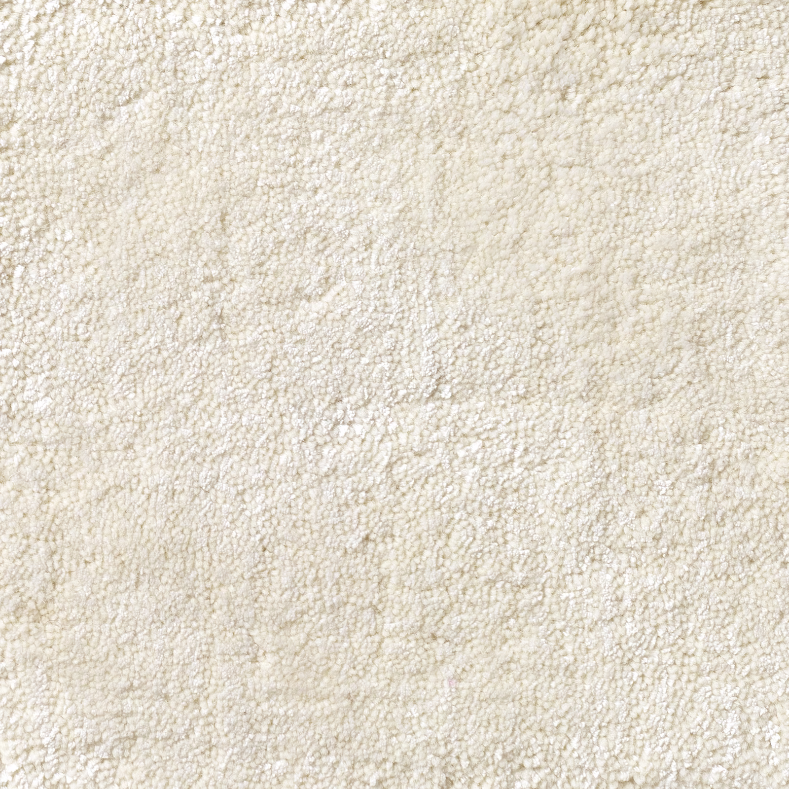 Soft ivory cream carpet showing dense irregular loops and subtle tonal flecks