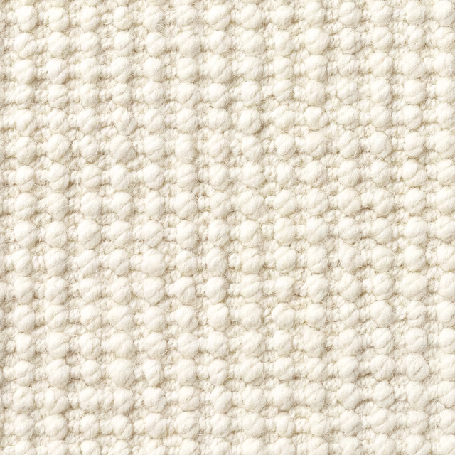 Warm cream textile with chunky irregular loops and softly mottled ivory texture
