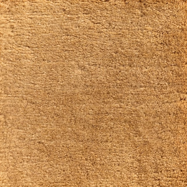 Close view of dense honey-brown carpet texture with softly mottled golden fibres