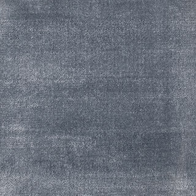 Close-up of muted cornflower blue-grey carpet with fine, grainy tonal texture