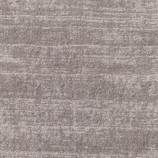 Warm dove-grey carpet textile with irregular horizontal bands and softly nubby woven texture