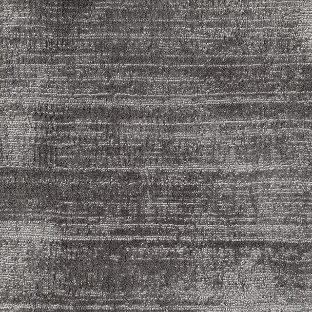 Mottled charcoal-grey carpet textile with irregular horizontal striations and nubby texture