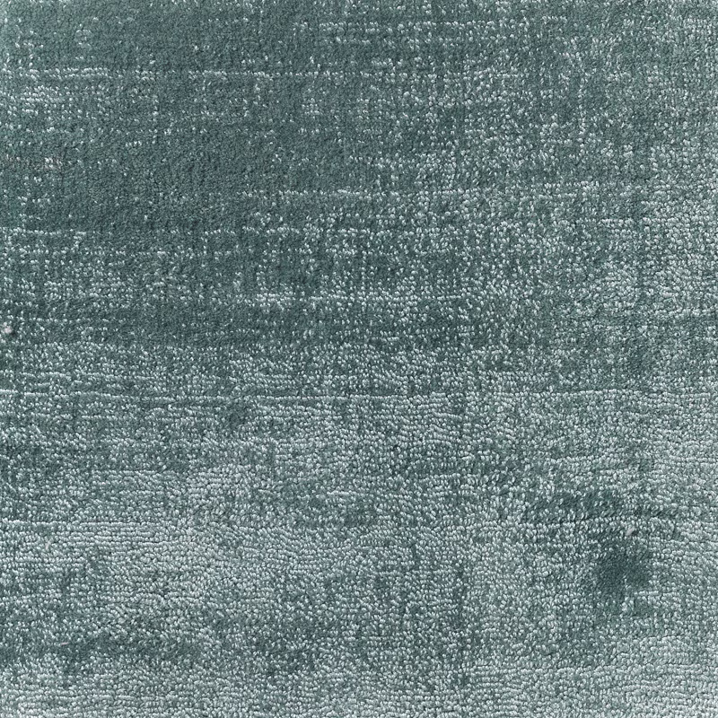 Close-up of muted duck egg blue-green carpet with dense mottled looped texture