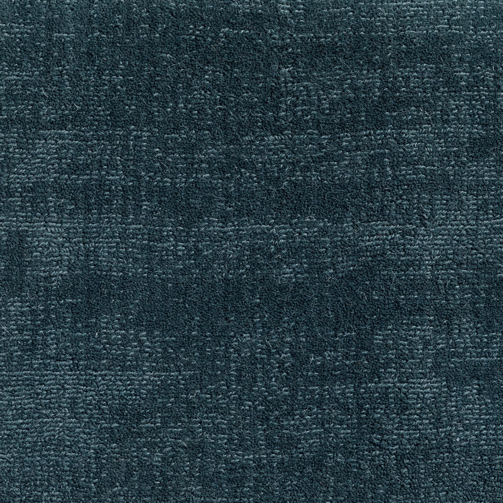 Deep woad blue-green carpet with dense mottled weave and charcoal-textured shading