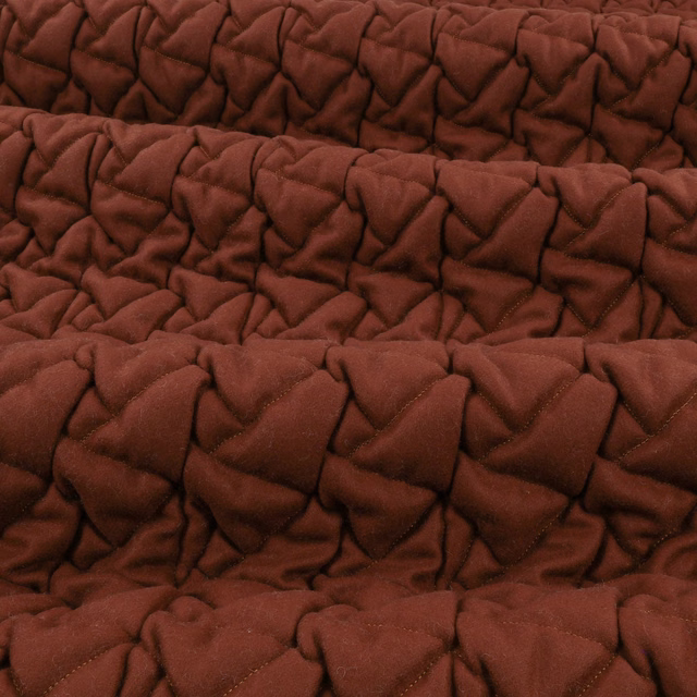 Deep conker-brown fabric with plush, irregular quilted folds and soft shadowed texture