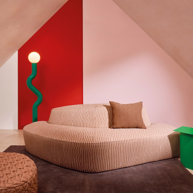 Warm terracotta upholstery with close-set pale linear ribs on a curved sofa