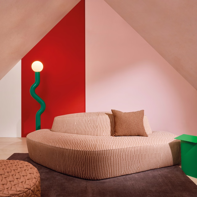 Warm pink-apricot fabric with fine vertical geometric stripes on a curved sofa