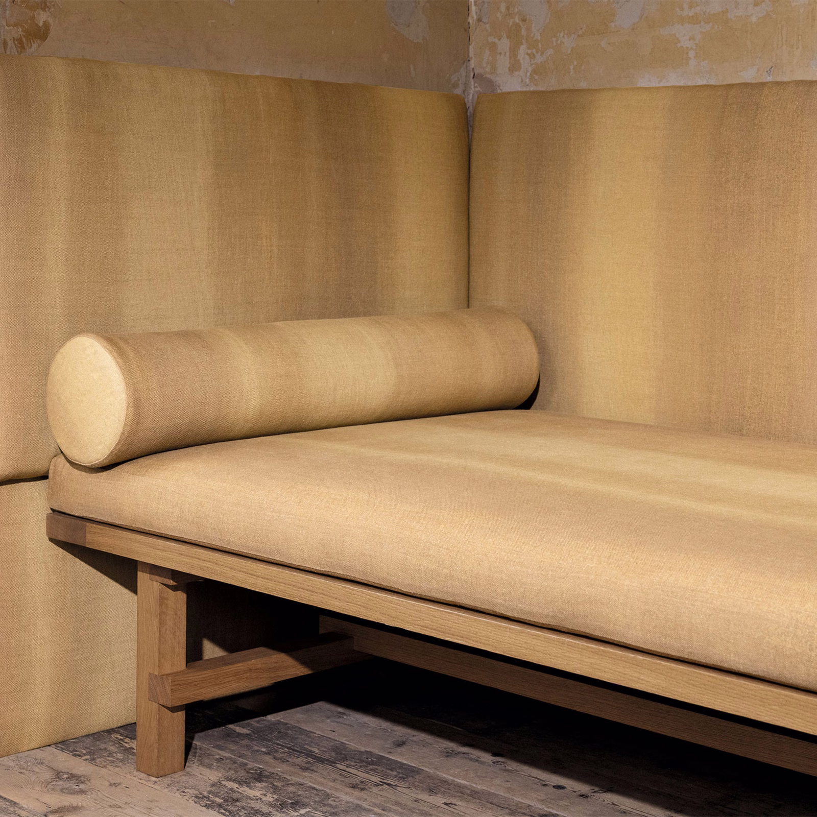 Warm harvest-gold plain weave upholstered on a timber-framed bench and bolster