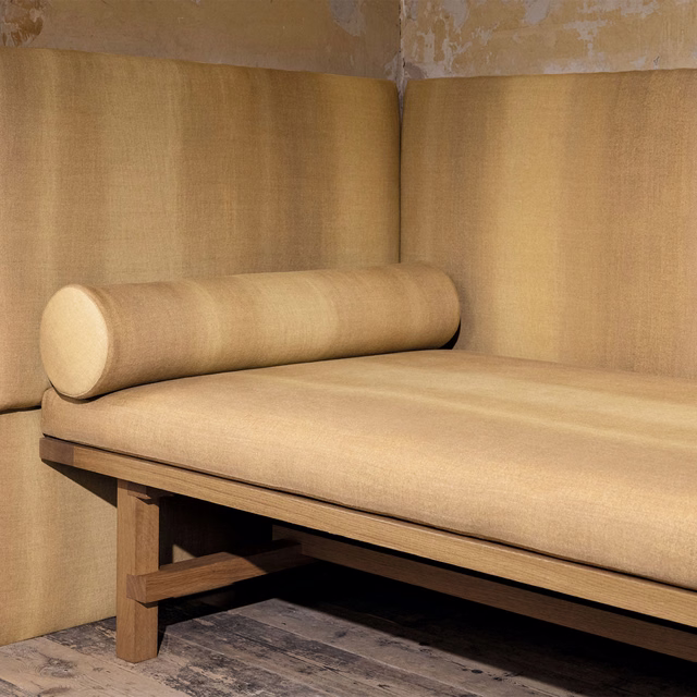 Warm harvest-gold plain weave upholstered on a timber-framed bench and bolster