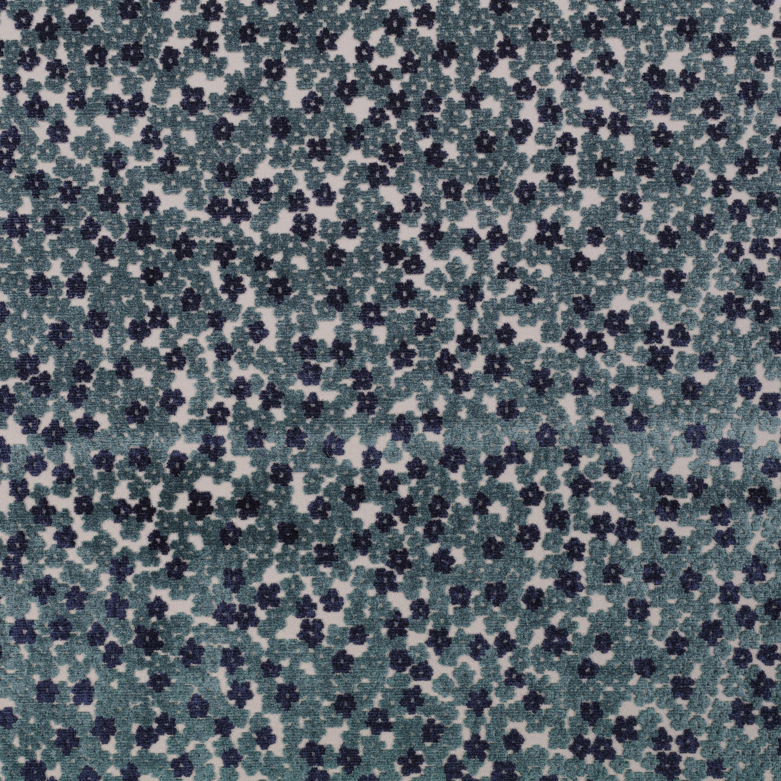 Close-up of muted teal fabric with navy floral clusters on a pale mottled ground