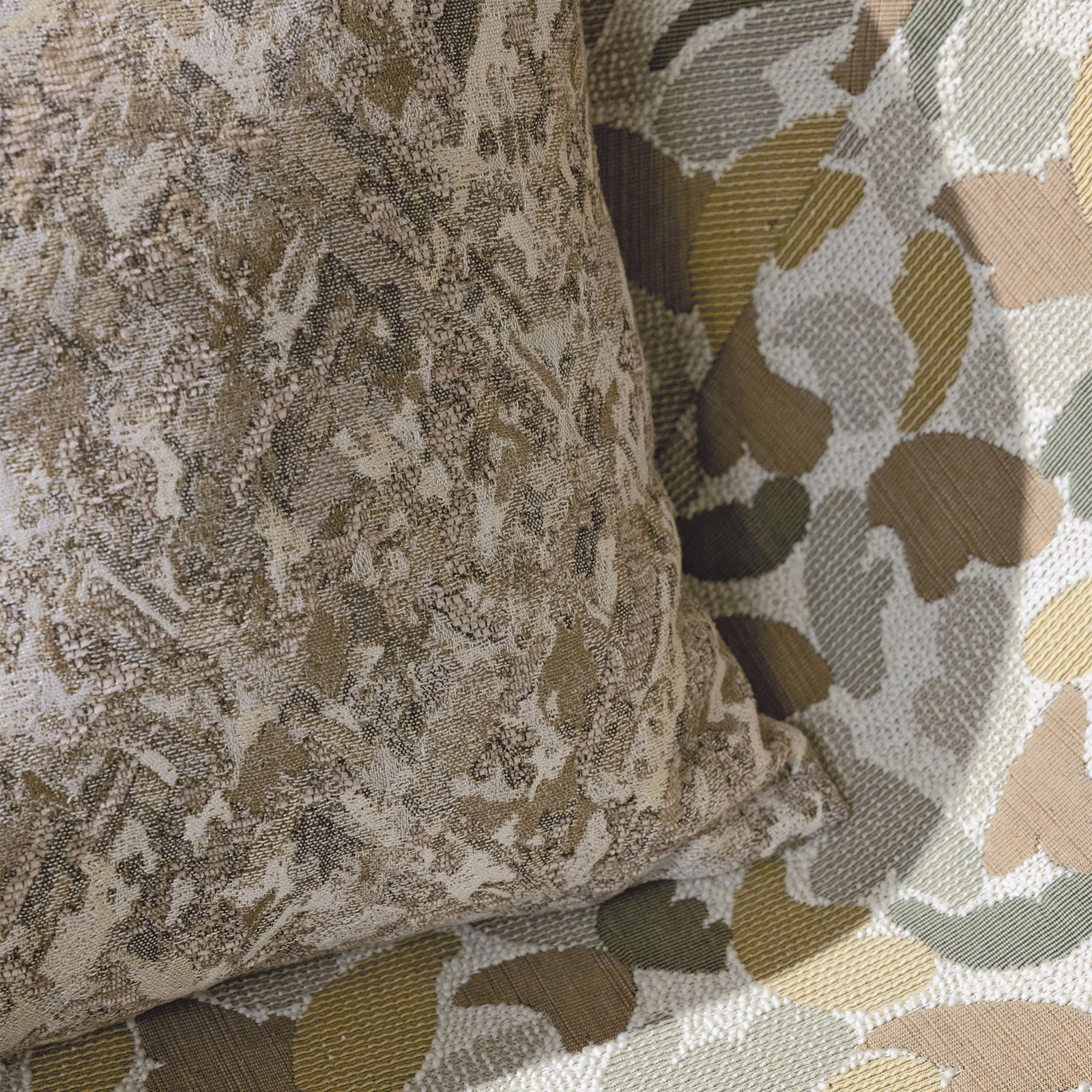 Warm buff woven fabric with mottled taupe markings and rounded abstract motifs