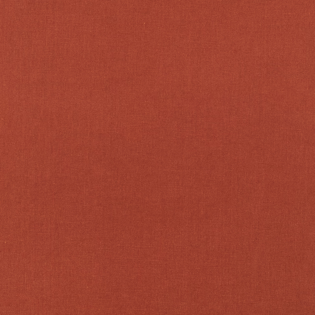 Warm terracotta-red fabric showing a subtle, fine woven texture in close-up