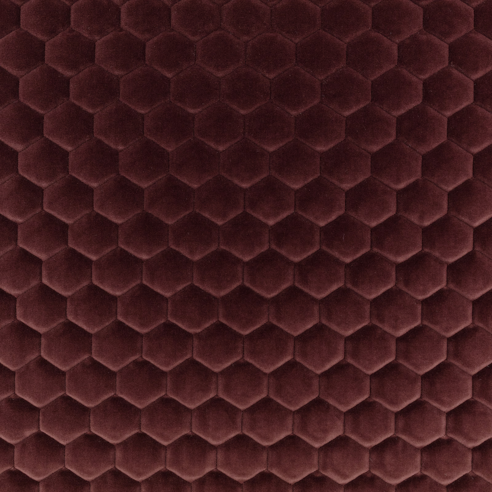 Deep burgundy fabric with raised plush hexagons and subtle plum shading