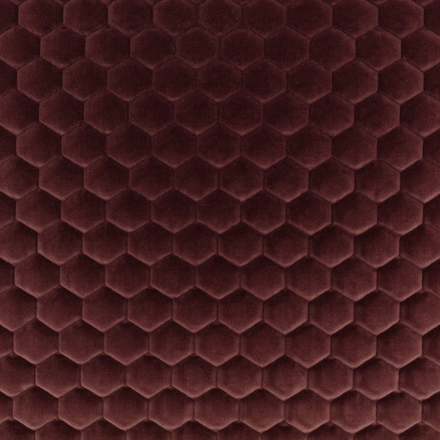 Deep burgundy fabric with raised plush hexagons and subtle plum shading
