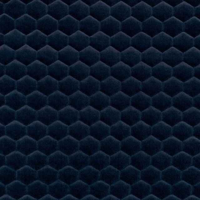 Deep marine-blue fabric with plush raised hexagonal cells and shadowed centres