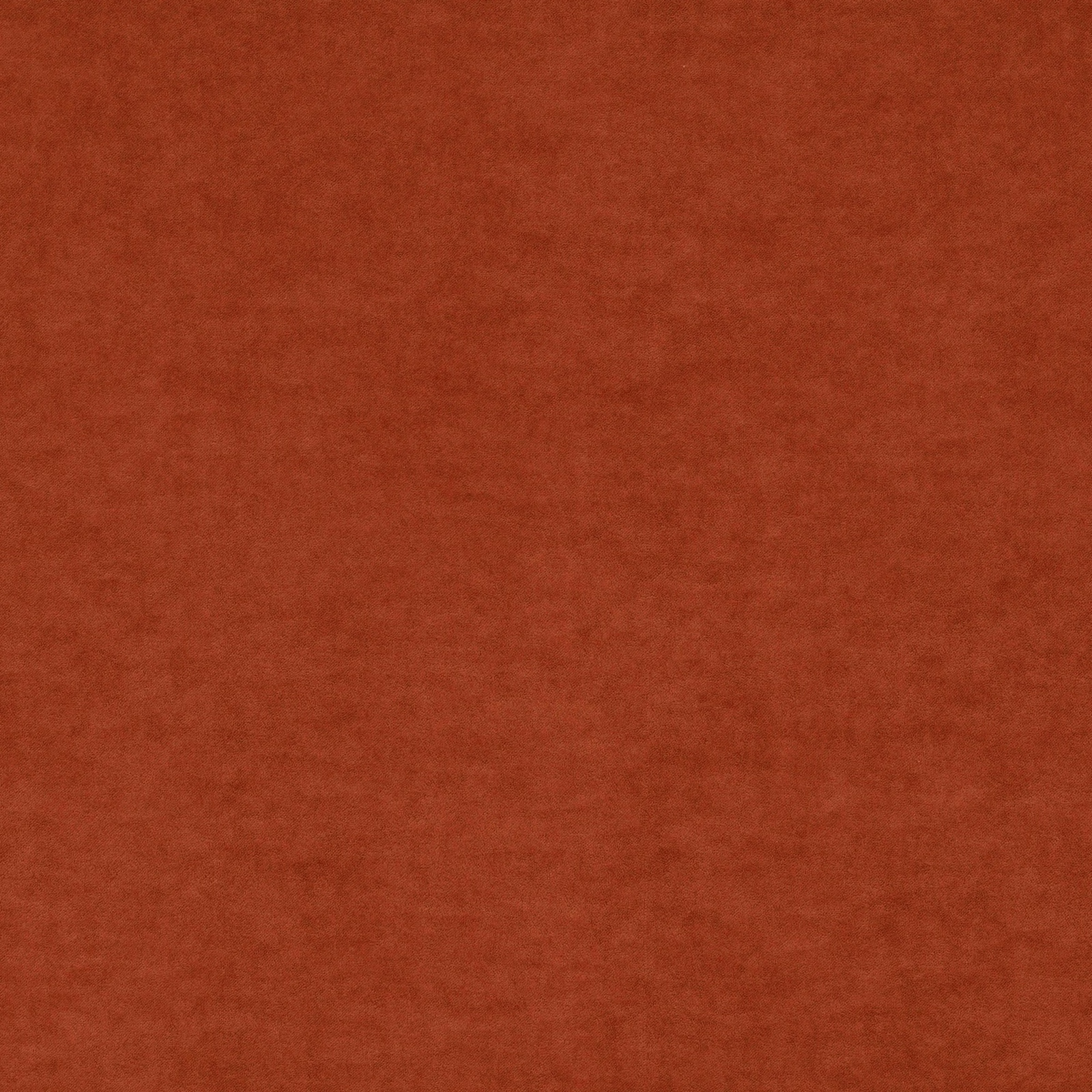 Close-up of warm rust terracotta fabric with softly brushed, mottled texture