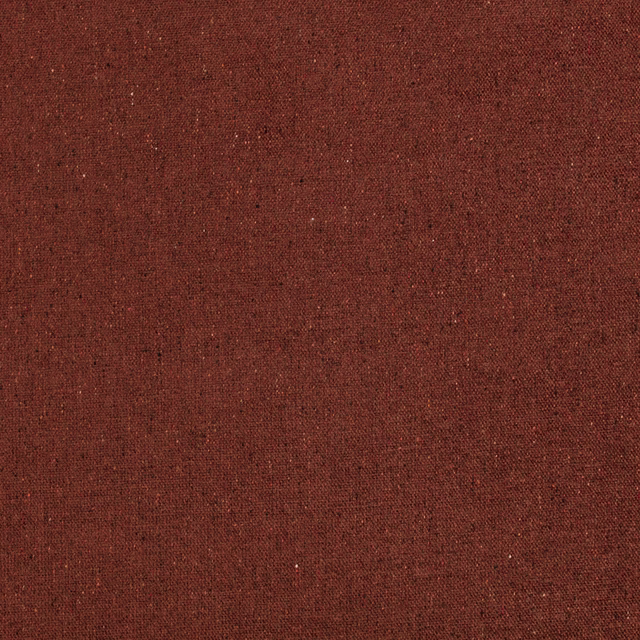 Close view of warm burnt-orange woven textile with fine dark flecks