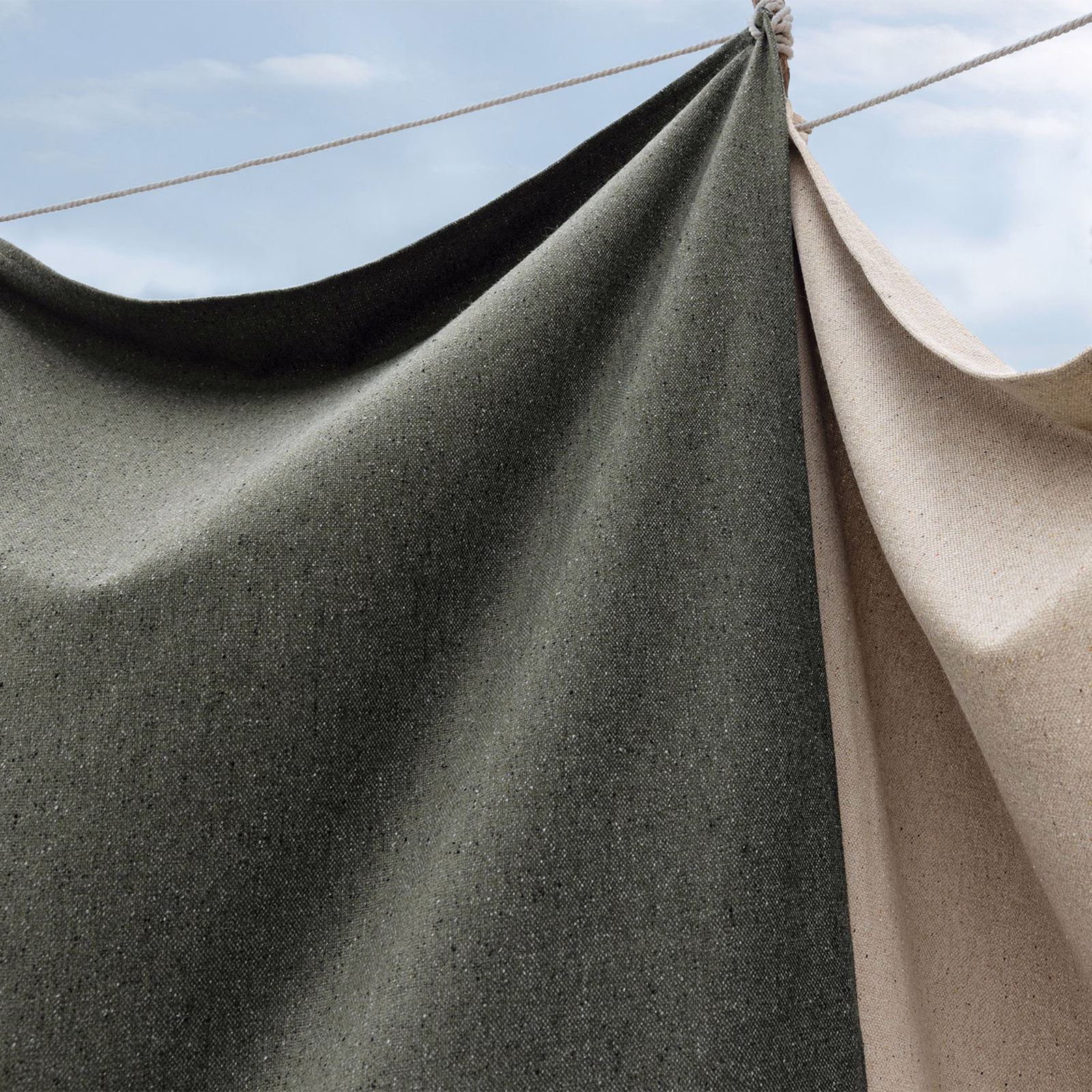 Dark khaki-green finely flecked weave hanging in broad, sculptural folds