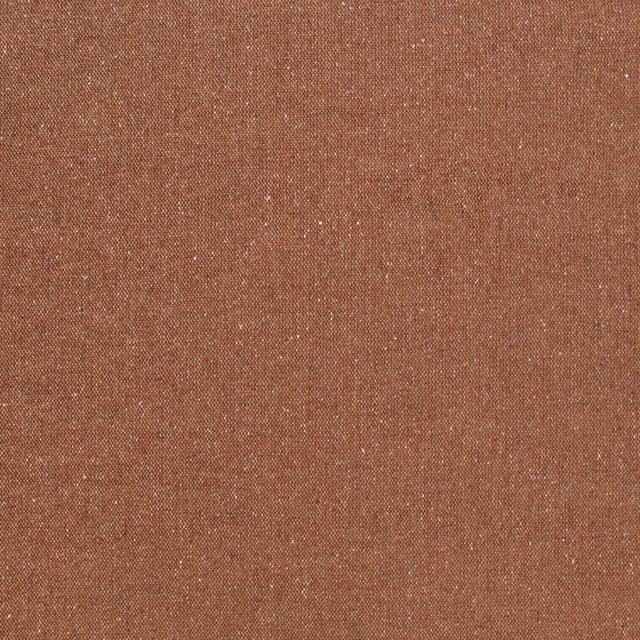 Close-up of warm terracotta fabric with fine pale flecks and a tight woven texture