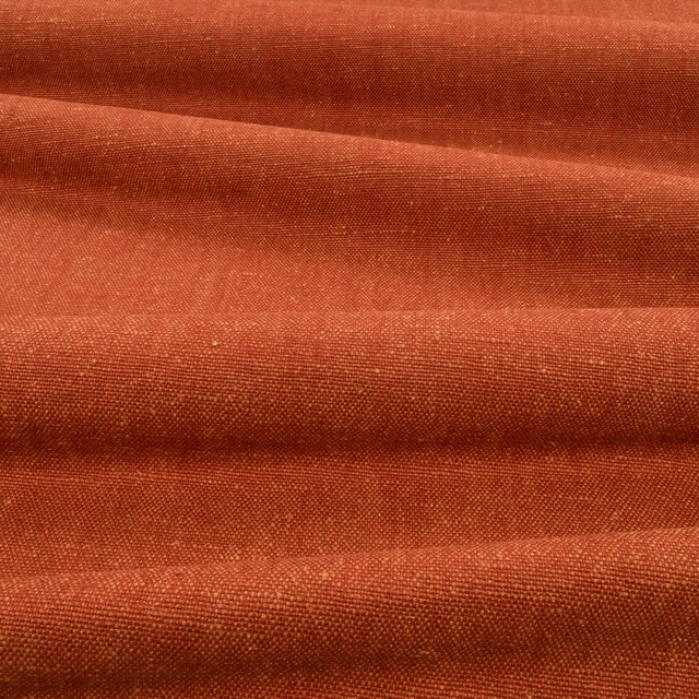 Burnt terracotta woven fabric with fine texture and darker folded ridges