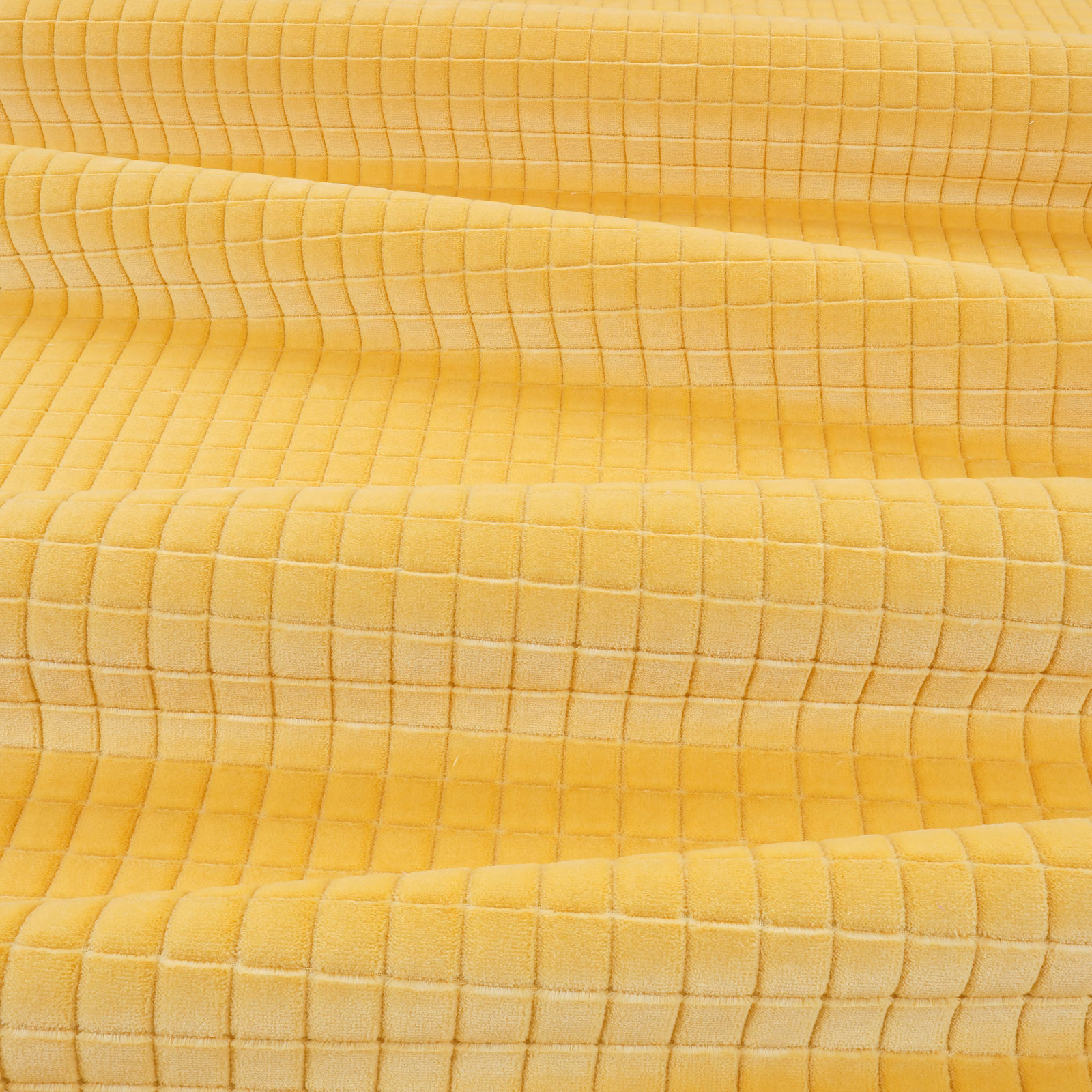 Close-up of warm custard-yellow fabric with a softly rippled square grid texture