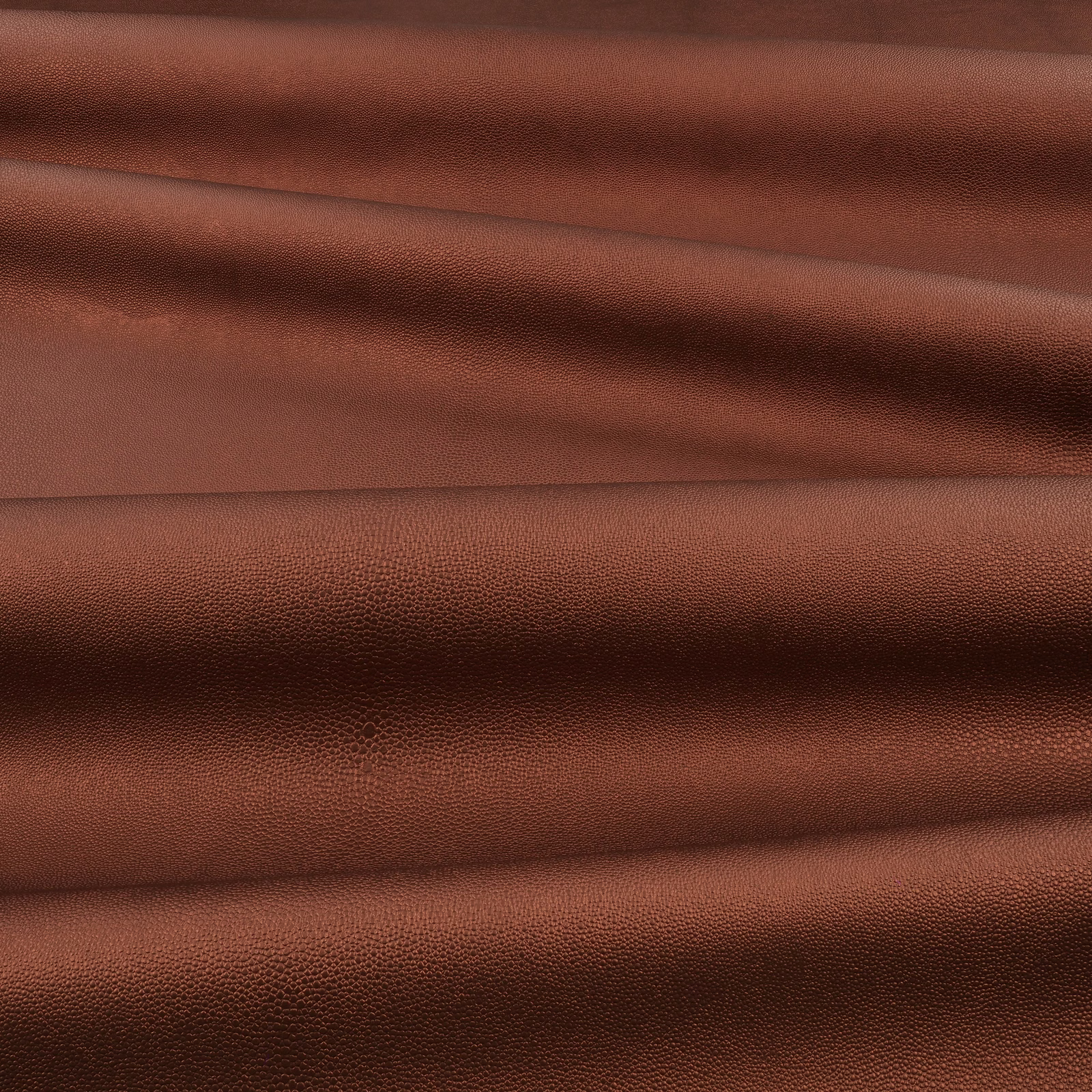 Warm russet-brown pebbled surface showing fine shagreen grain across soft layered folds