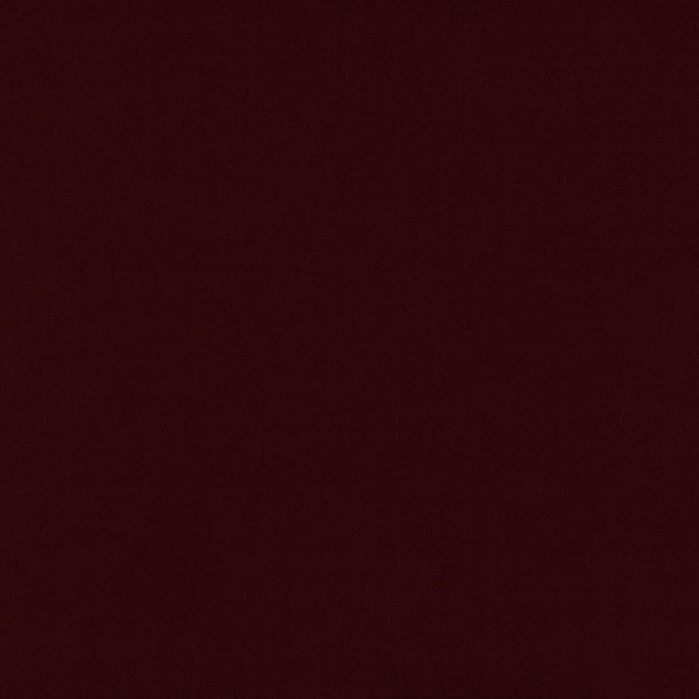 Deep ruby burgundy fabric with a subtle, dense plain weave and softly mottled surface