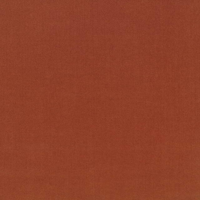 Close view of muted burnt terracotta cloth with a fine, softly textured weave