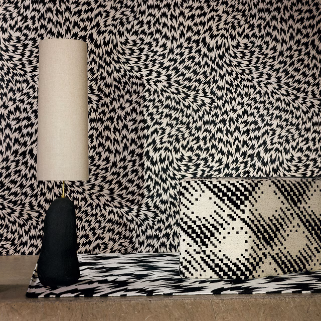 Black and cream swirling abstract woven textile on chair, cushion and floor
