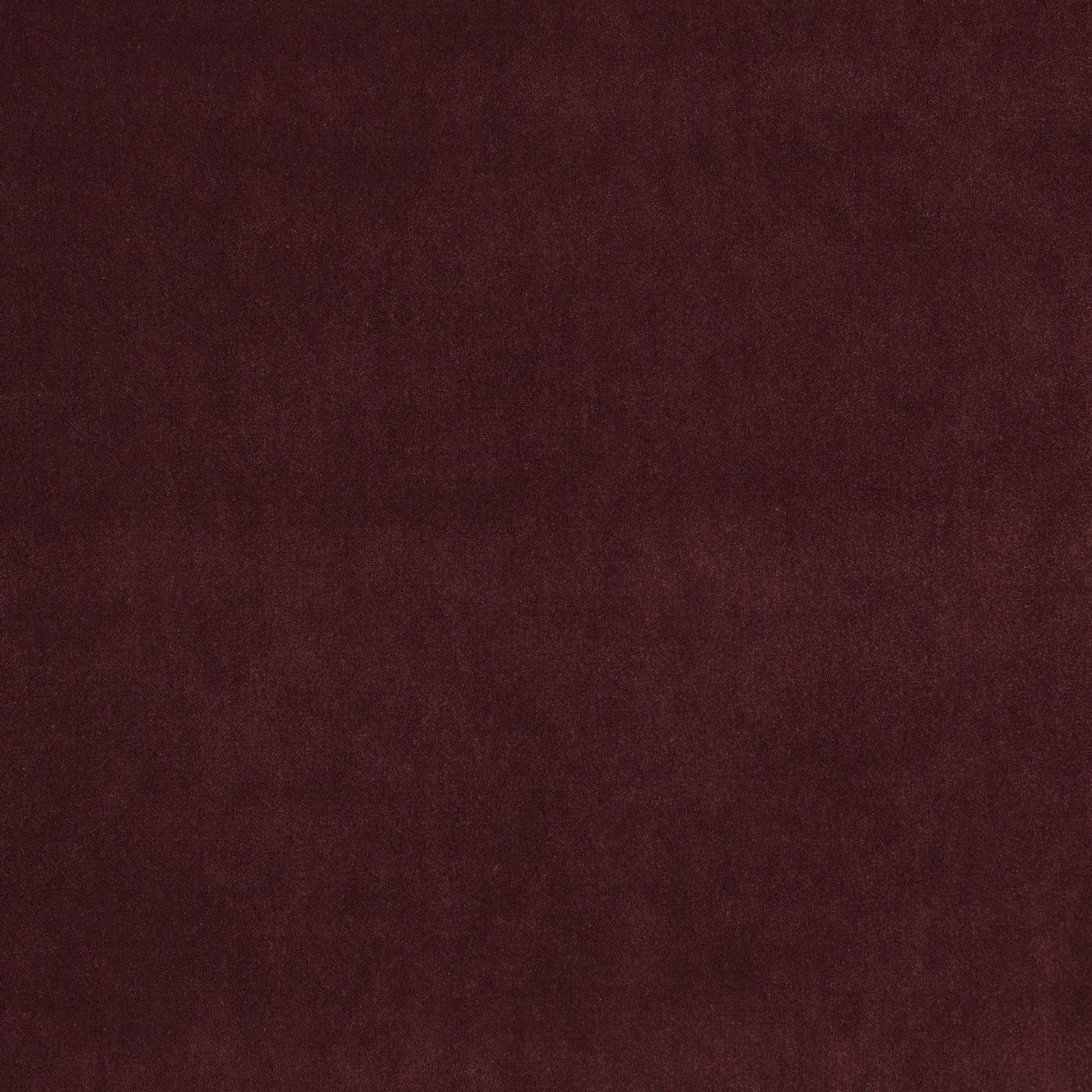 Close-up of dark plum fabric with a softly mottled, low-sheen surface