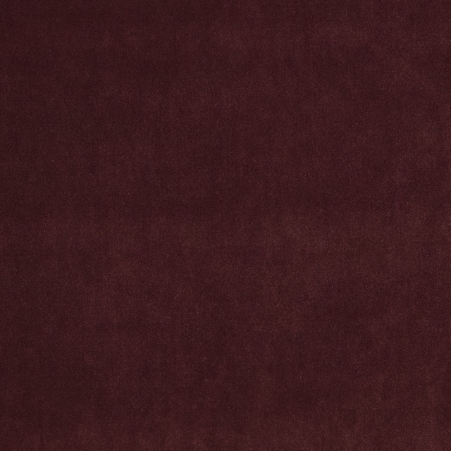 Close-up of dark plum fabric with a softly mottled, low-sheen surface