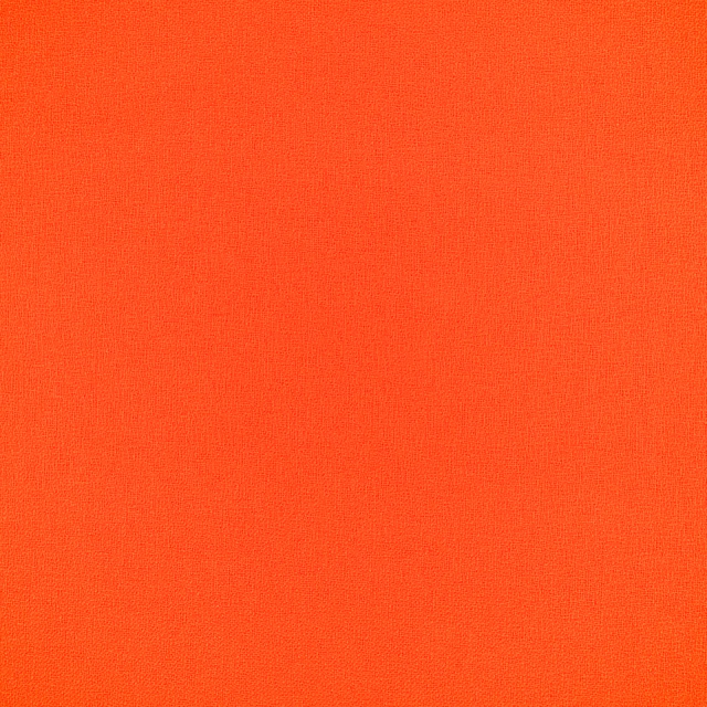 Close-up of finely woven saturated blood orange outdoor upholstery fabric