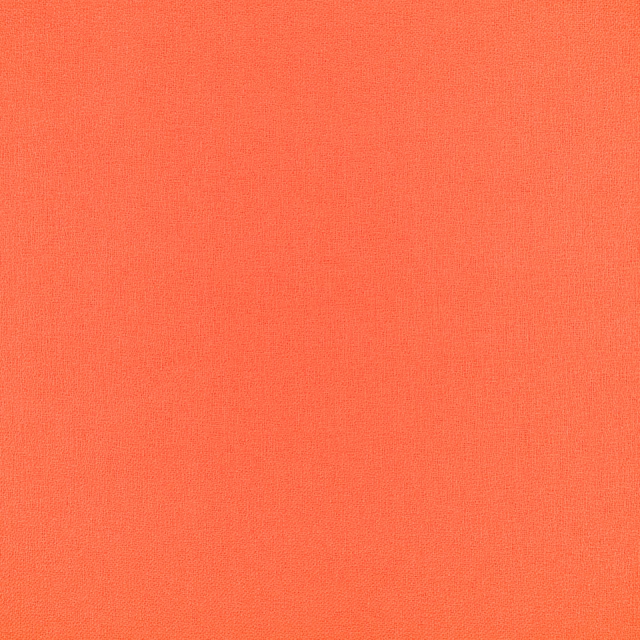 Close-up of vivid grapefruit coral-orange fabric with a fine, even plain weave