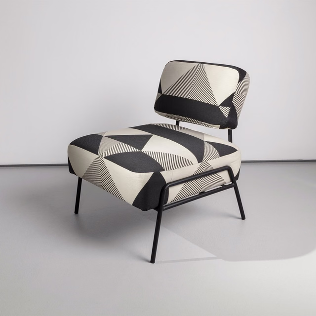 Black and ivory geometric textile with striped triangles on an upholstered lounge chair