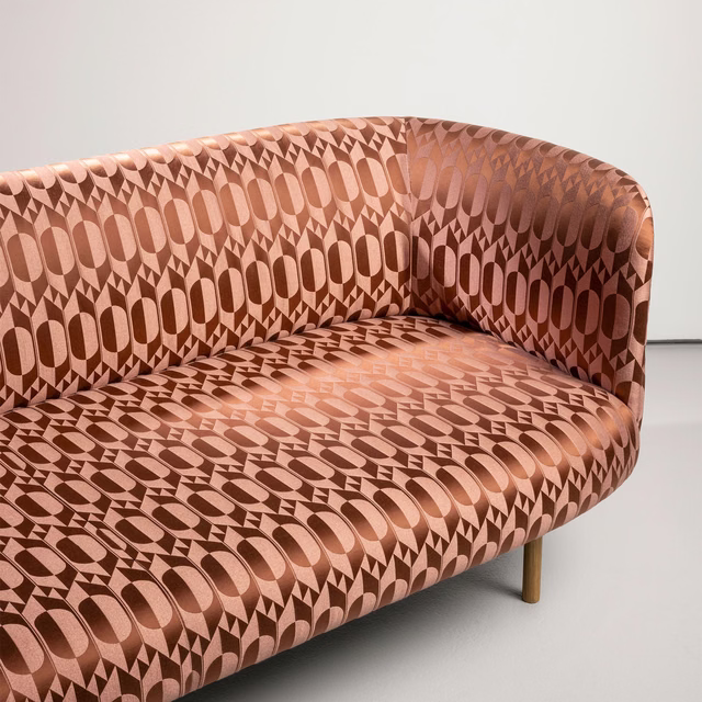 Warm clay geometric upholstery with oval and diamond motifs on a curved sofa