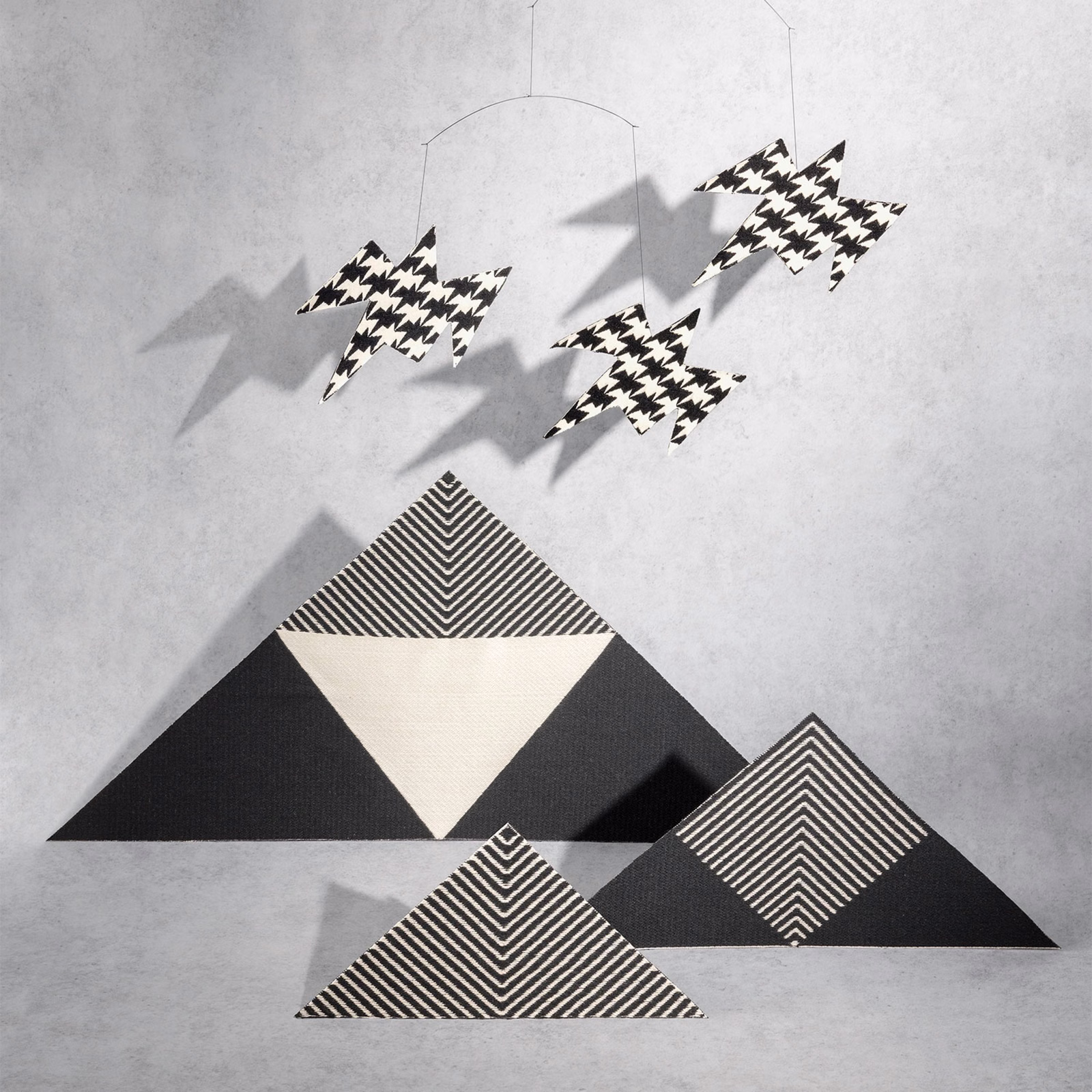 Black-and-white zigzag birds above bold chevron and triangular motifs