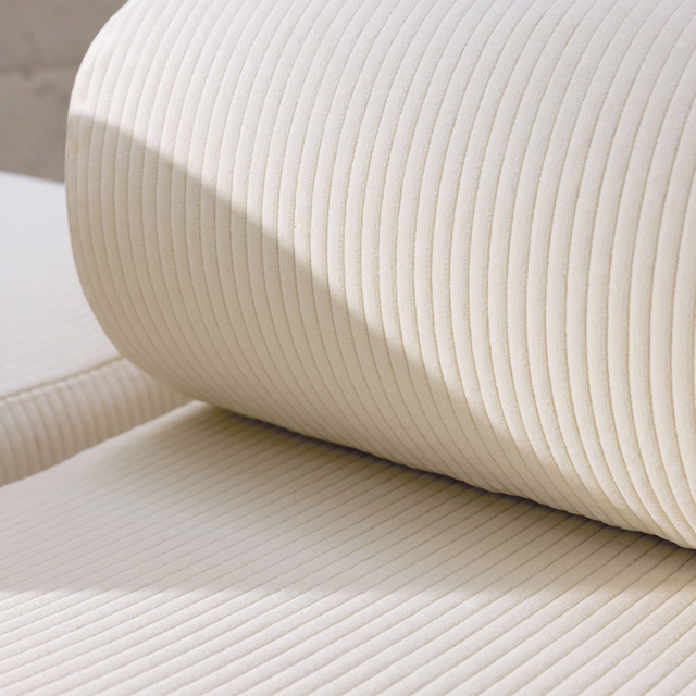 Warm ivory cream ribbed upholstery textile draped over a curved padded form