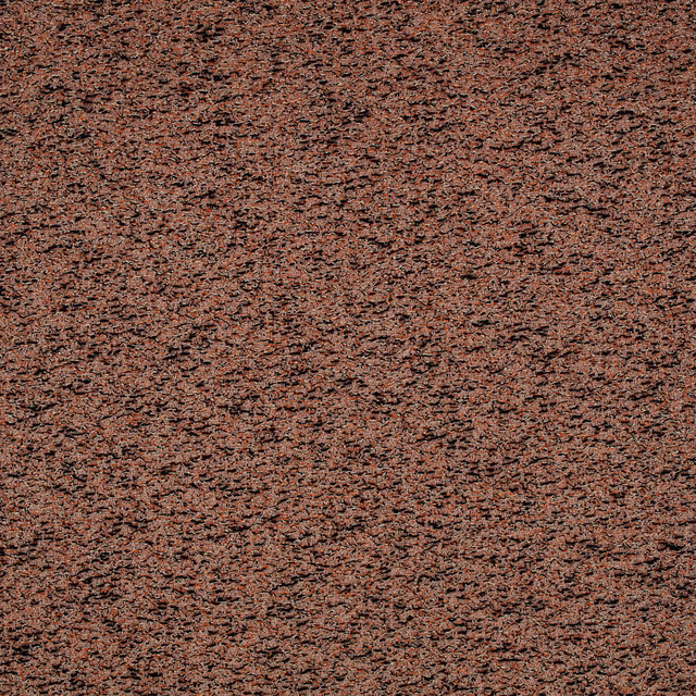 Clay-terracotta textile with dark flecks and irregular horizontal slub texture