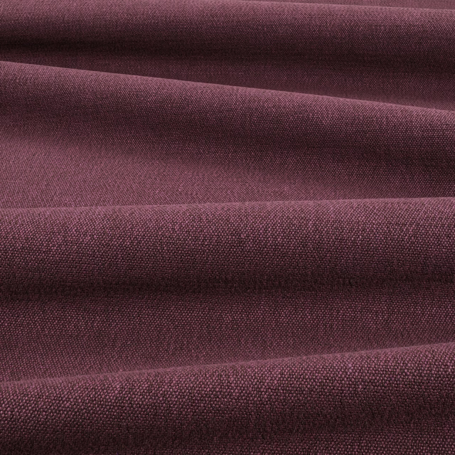 Deep fig-plum woven fabric folded to reveal a fine, tactile surface