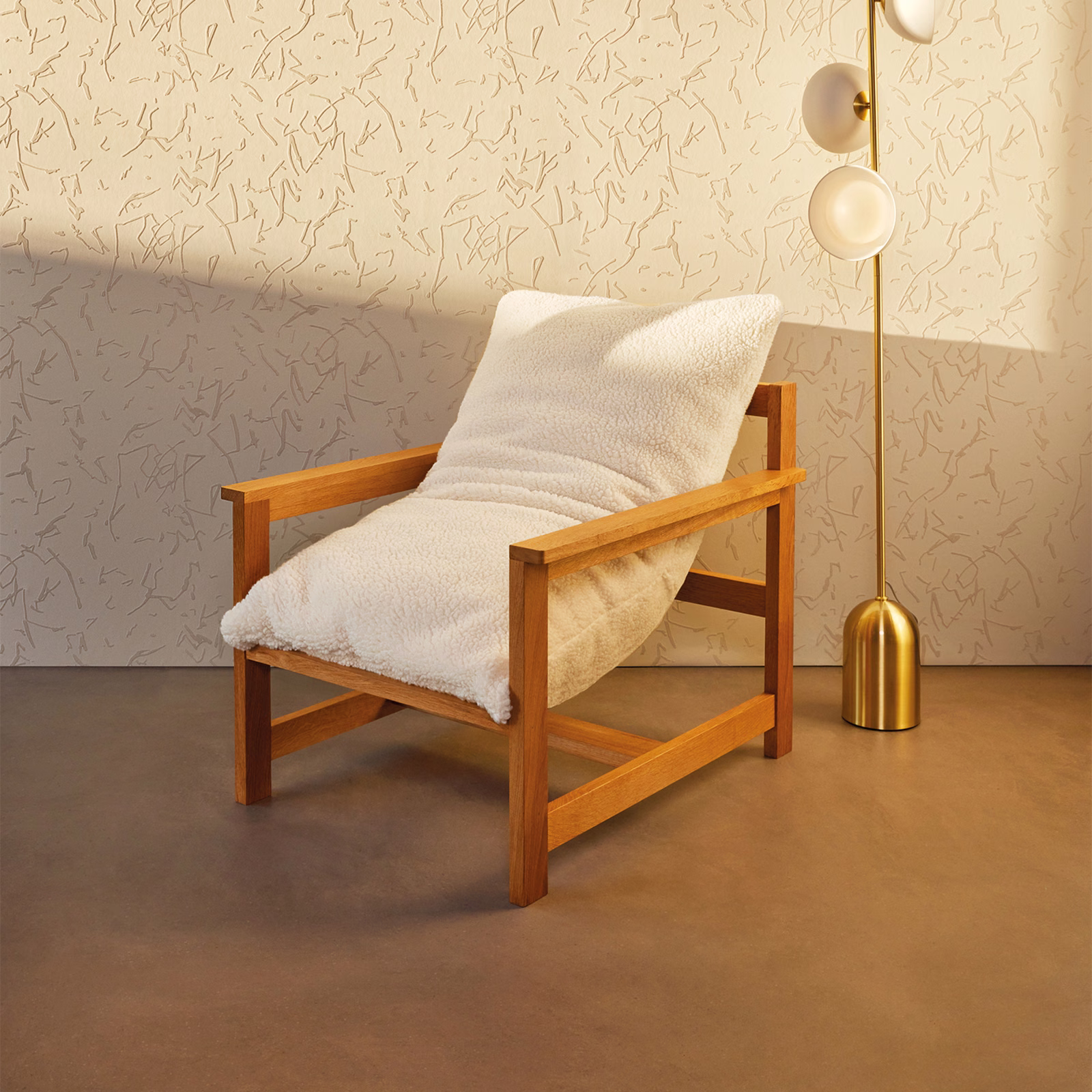 Chalk ivory fleeced upholstery covering a timber armchair in warm angled light