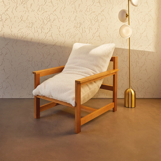 Chalk ivory fleeced upholstery covering a timber armchair in warm angled light