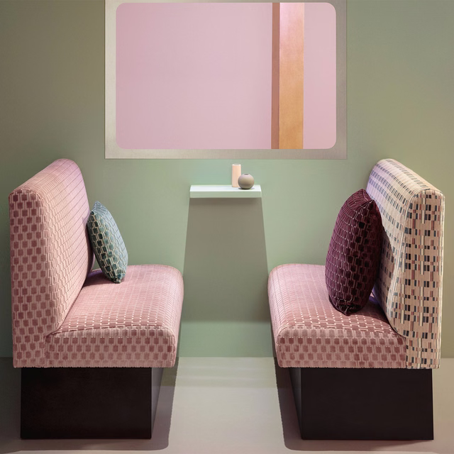Blush pink geometric check fabric upholstered on two contemporary lounge chairs