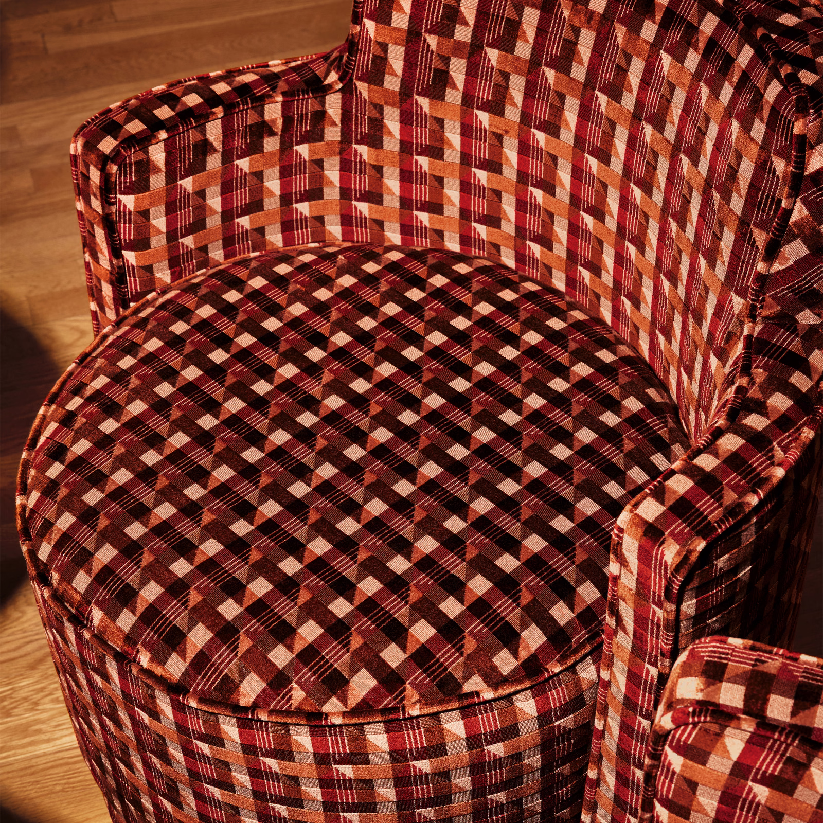 Deep burgundy, black and cream checked upholstery across a rounded chair