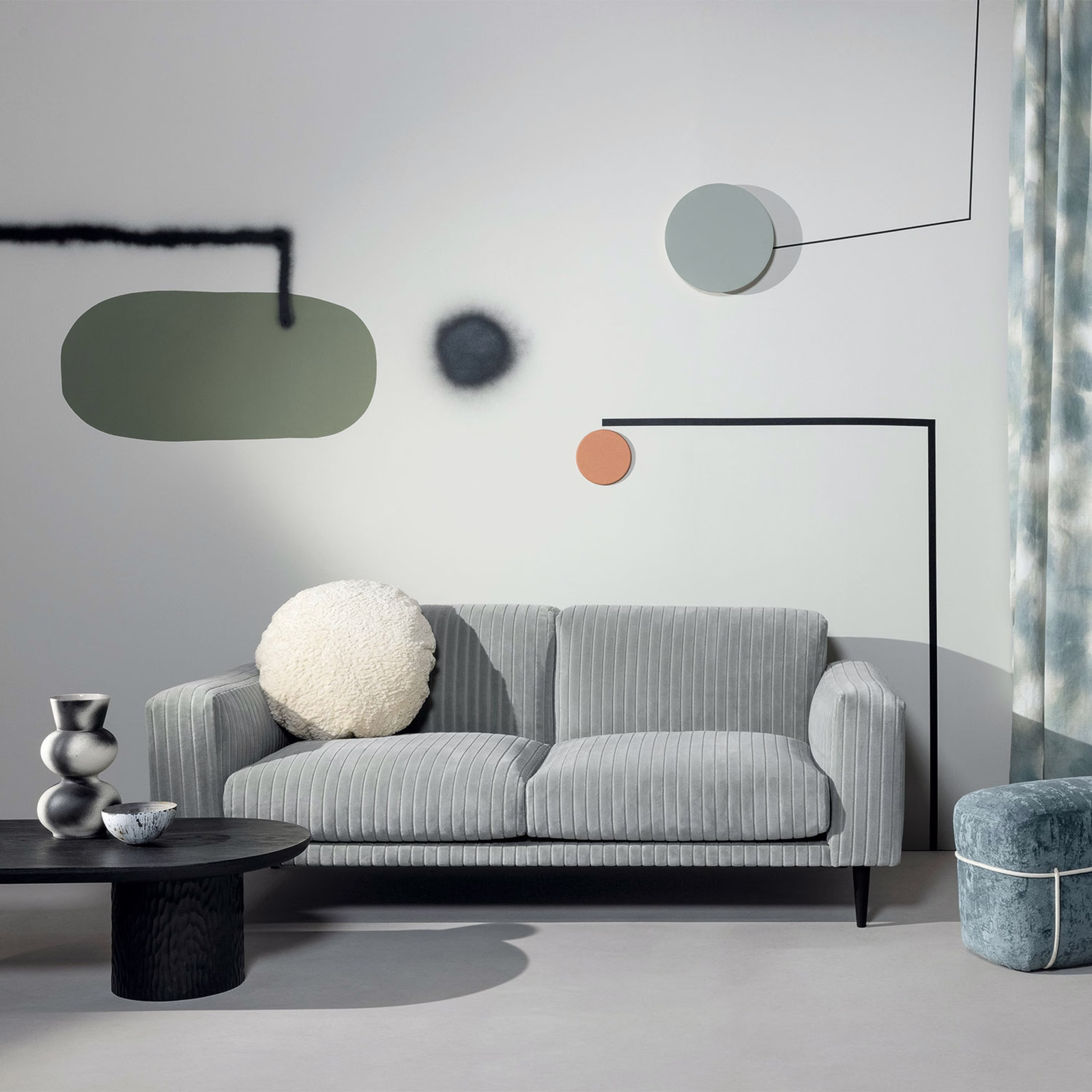 Cool aqua-grey ribbed upholstery covering a contemporary sofa in a light modern room