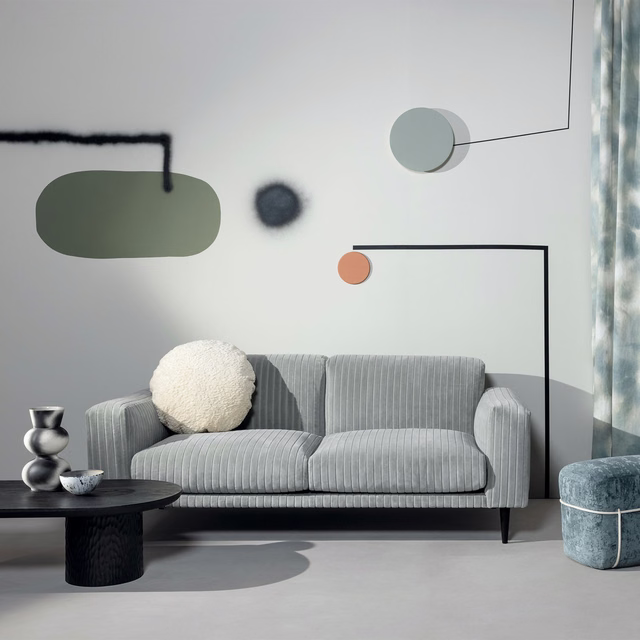 Cool aqua-grey ribbed upholstery covering a contemporary sofa in a light modern room