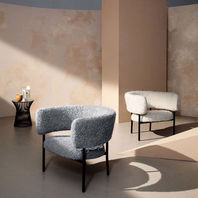 Cool glacier-grey nubby upholstery covering rounded lounge chairs in strong sunlight