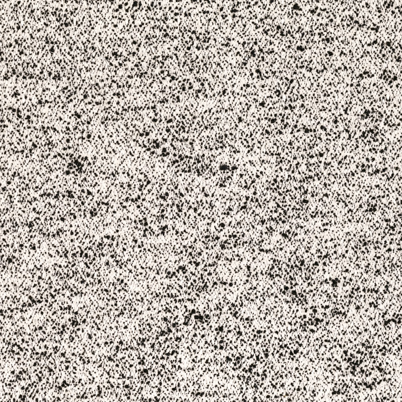 Ivory fabric densely scattered with irregular black flecks and tactile woven texture