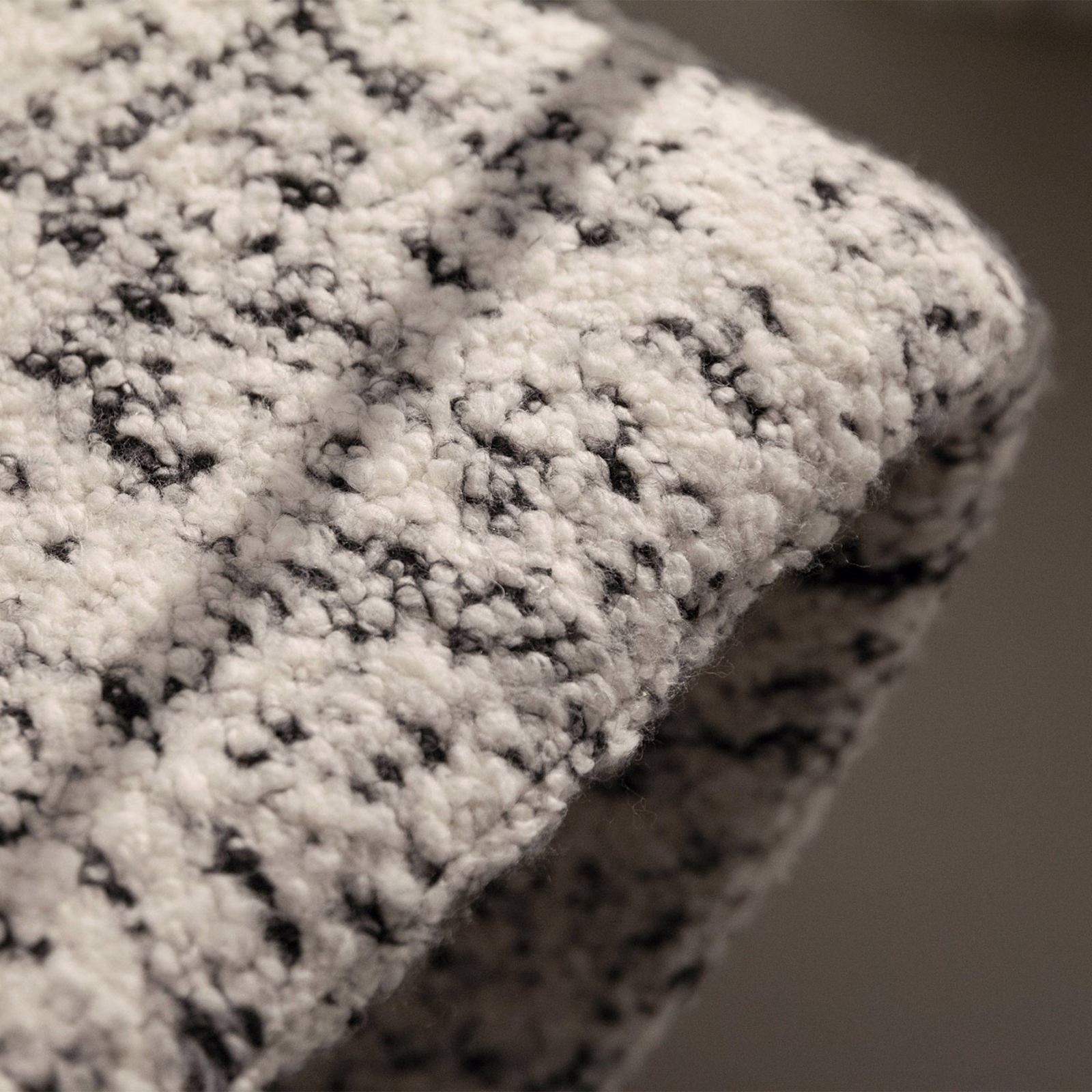 Ivory bouclé upholstery fabric with irregular charcoal flecks and a chunky raised texture