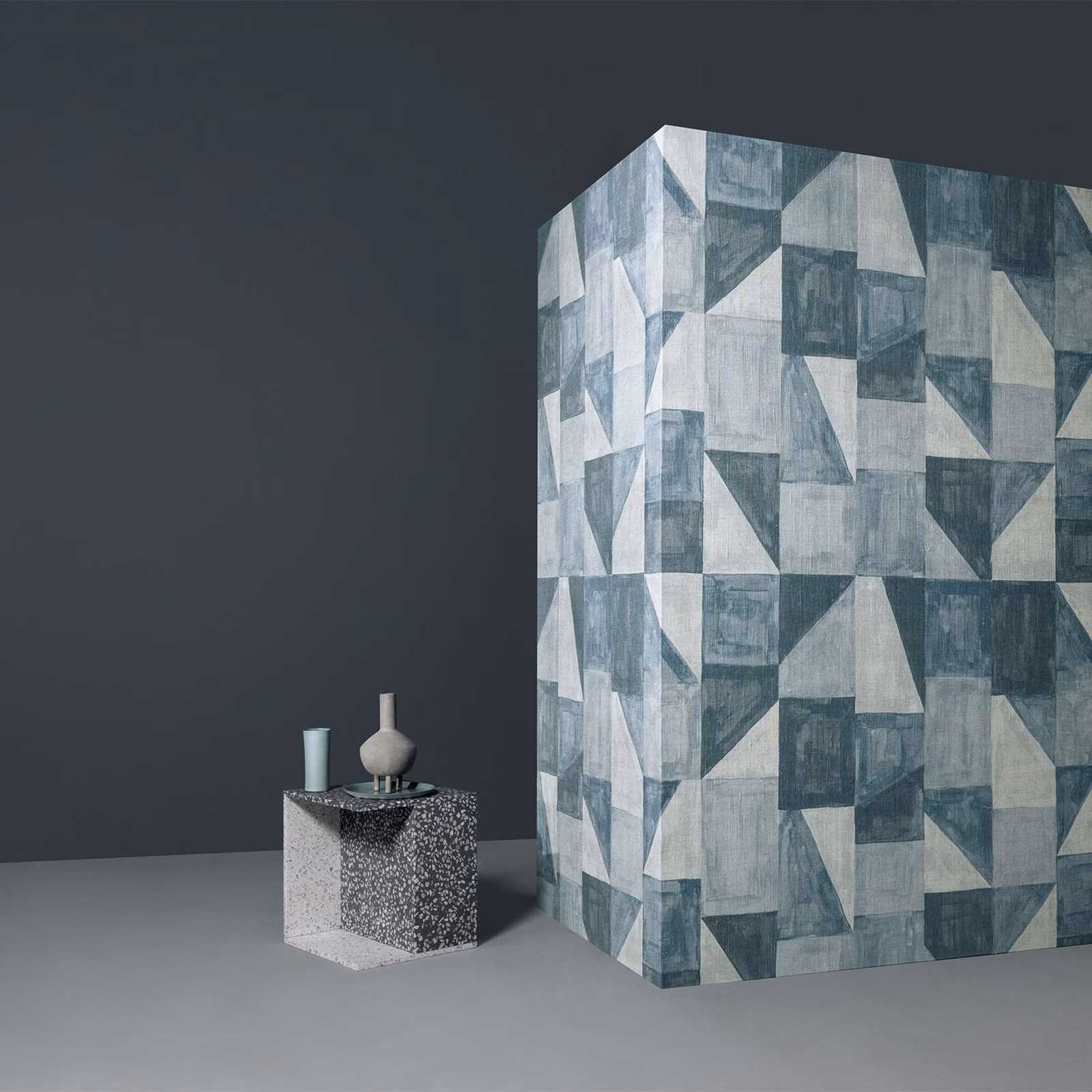 Blue-grey geometric wall mural with weathered angular blocks in a staged interior